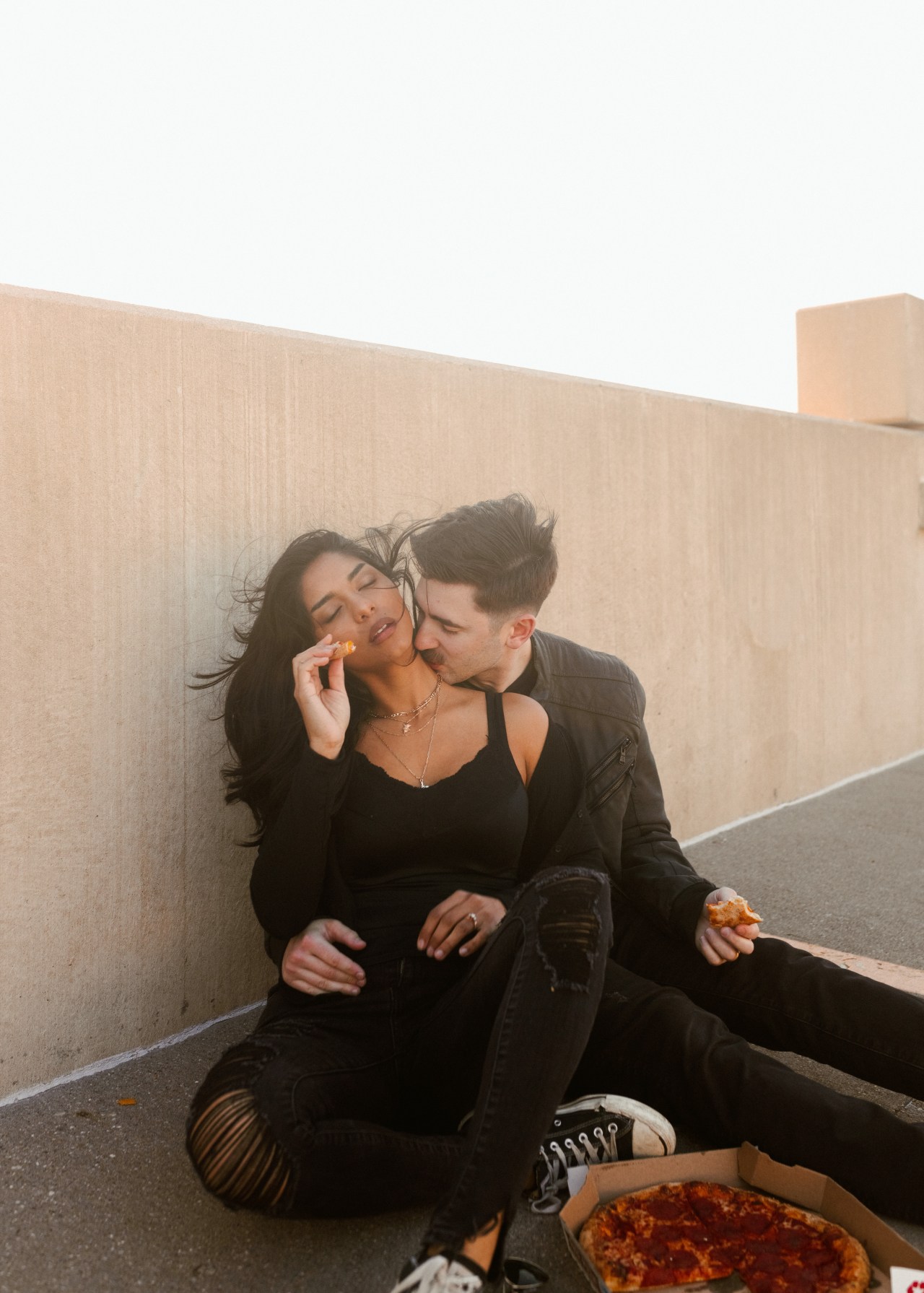 Couple Kissing and Eating Pizza
