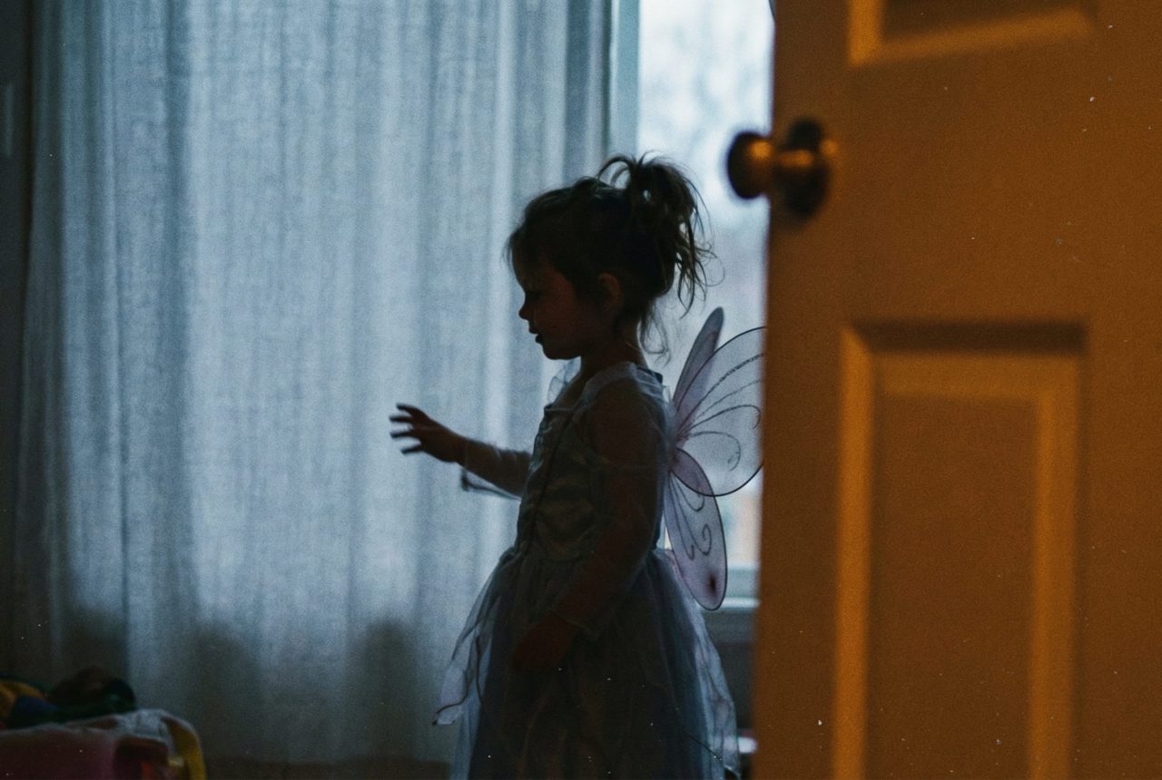 young girl with fairy wings in her bedroom playing