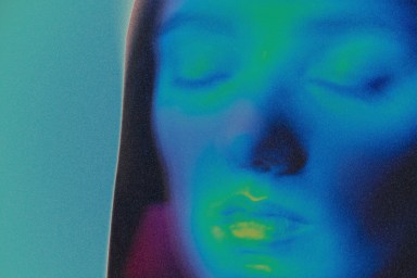 Woman's face glowing with thermal infrared heat colors in vibrant abstract portrait