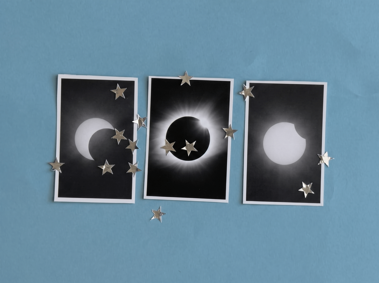 Three eclipse phase photos on blue background surrounded by silver star confetti, showing partial crescent, full totality with corona, and partial phase.