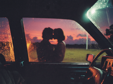 Silhouettes of two people kissing outside a vintage car, framed through a rain-dotted window against a pink and orange sunset sky.