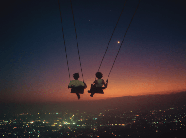 Illustration of two people on swings above a city at sunset.
