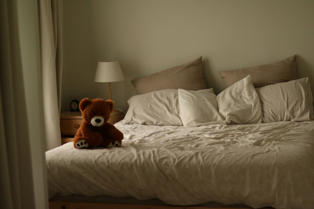 a teddy bear sitting on top of a bed