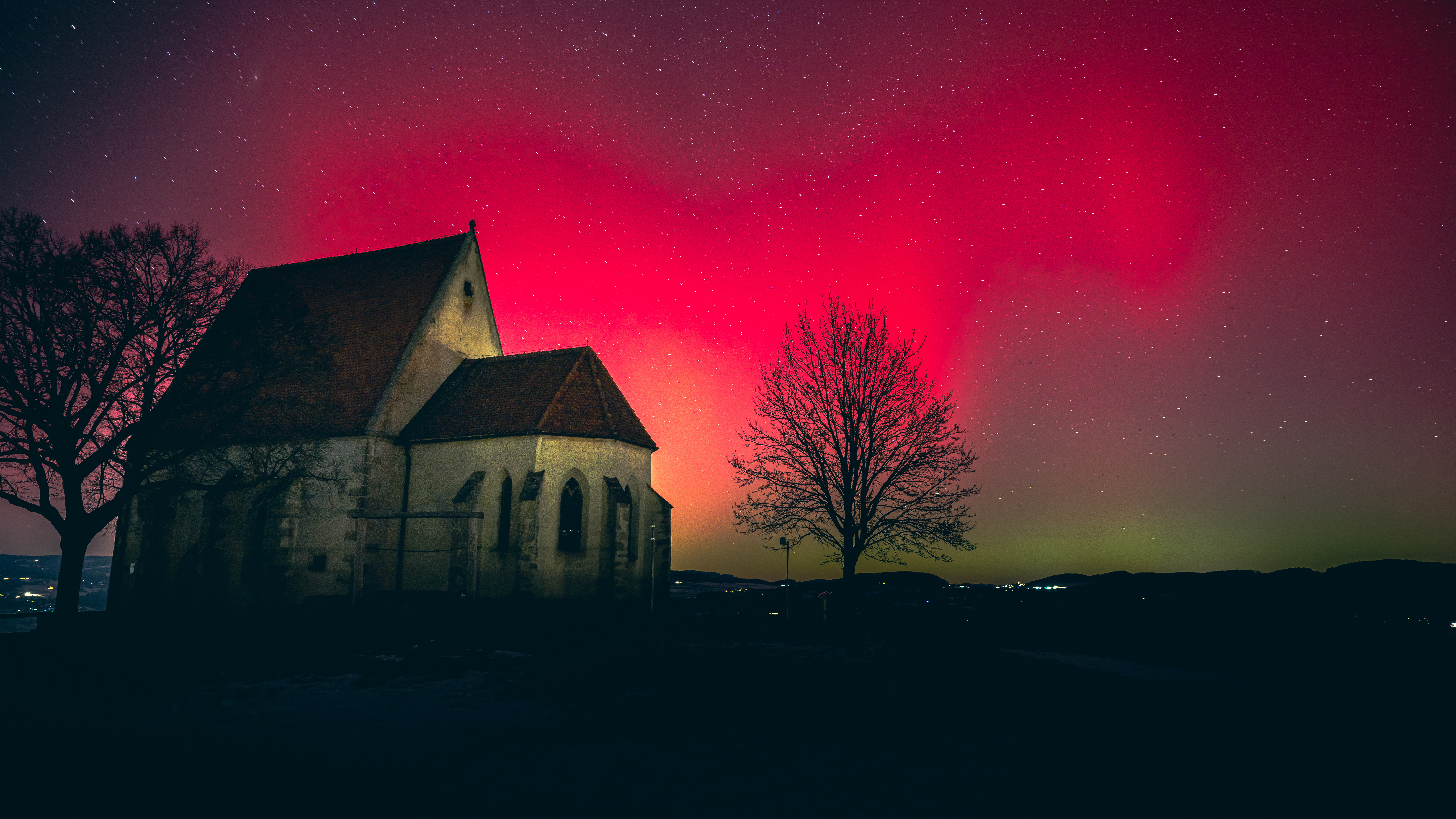 Aurora borealis glowing in the night sky above the Wenzel church in Wartberg ob der Aist, Upper Austria.